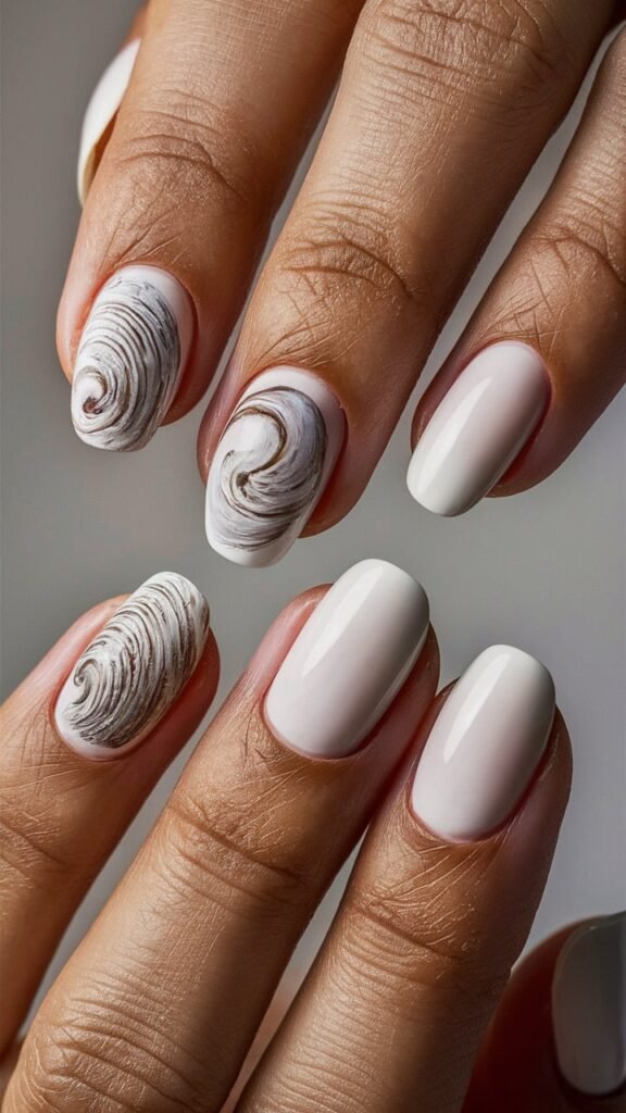 Soft white nails with one accent nail featuring a large, hyperrealistic shell. The shell has a pearlescent finish with detailed ridges and curves, making it appear almost as though it’s been placed directly from the beach. The nails have a glossy finish that enhances the elegance and beachy charm of the design.