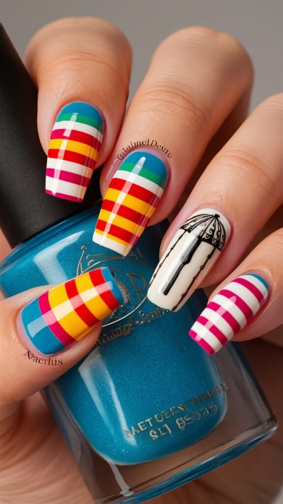 Nails with colorful stripes inspired by classic beach umbrellas, featuring bright and bold colors. One or two nails include small, detailed umbrella designs that add to the summery, playful theme. The nails have a glossy finish that enhances the vibrant colors and crisp stripes, creating a fun, beach-ready look perfect for sunny days.