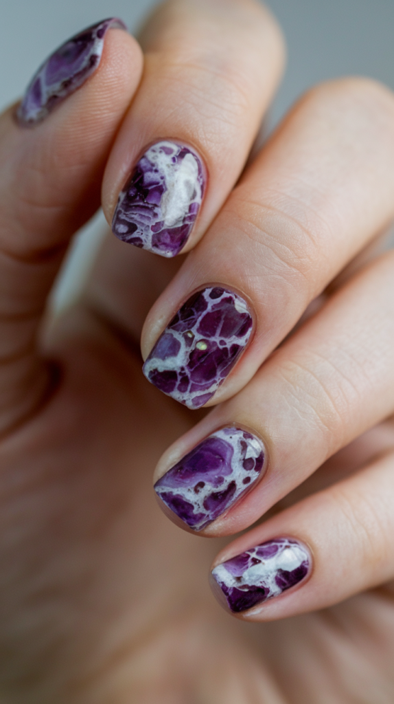 Nails resembling polished amethyst gemstones with intricate marble veining in purple