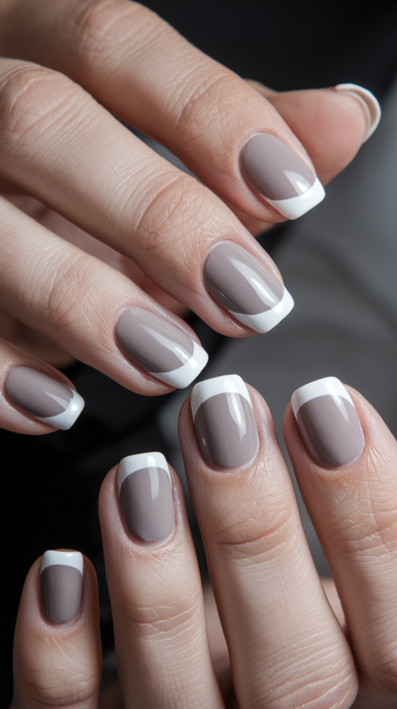 Minimalist nails with small geometric shapes, like triangles and squares, in muted tones