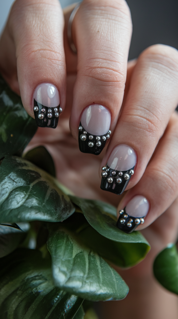 Edgy black nails adorned with shiny studs and rhinestones, providing a textured and glamorous appearance