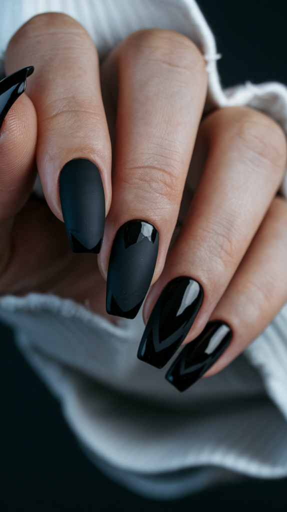 Matte black nails with glossy black tips, showcasing the contrast between velvety matte texture and shiny, sleek tips for a bold yet sophisticated look.

