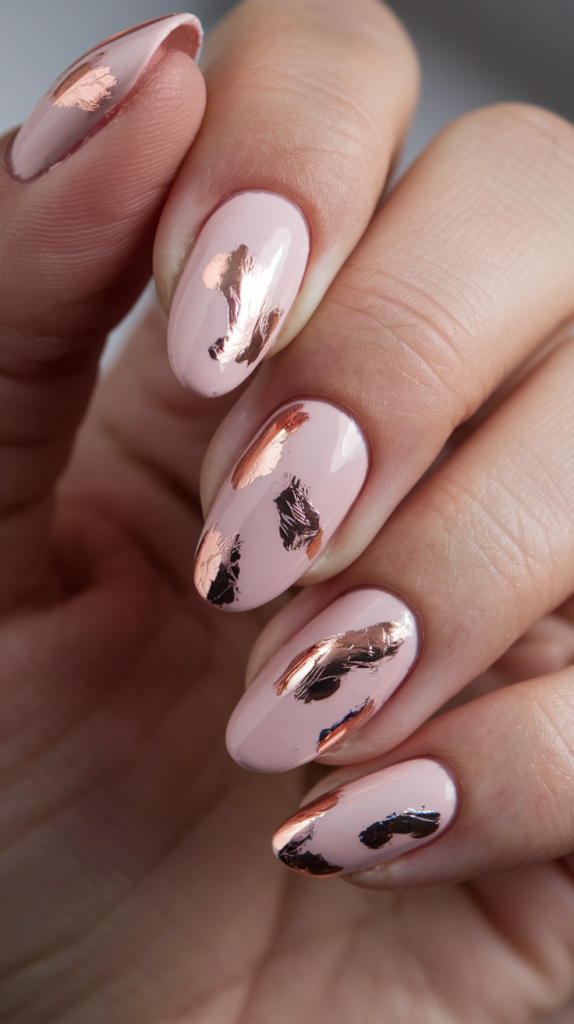 Soft pink nails accented with rose gold foil and striping details for a luxurious finish