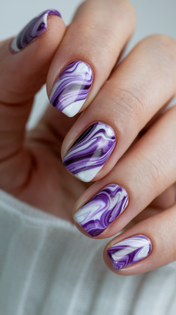 Swirled purple and white tie-dye nail art with a glossy finish for a fun, free-spirited look.