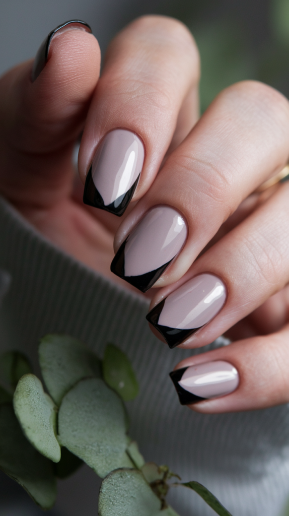 Minimalist nails with small geometric shapes, like triangles and squares, in muted tones