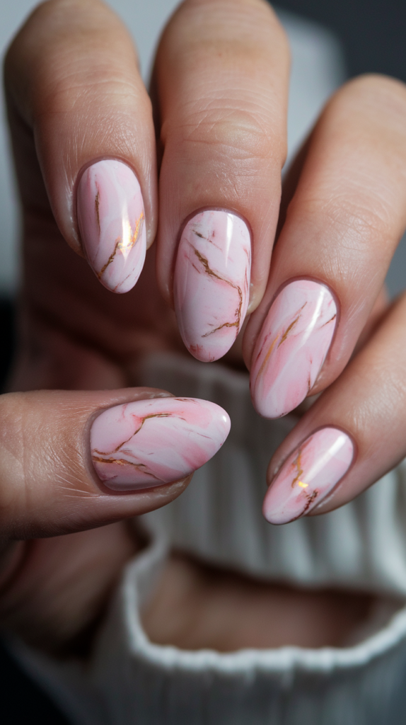 Pink marble acrylic nails with subtle gold veins, blending soft pink tones with luxurious gold accents for an elegant and feminine look