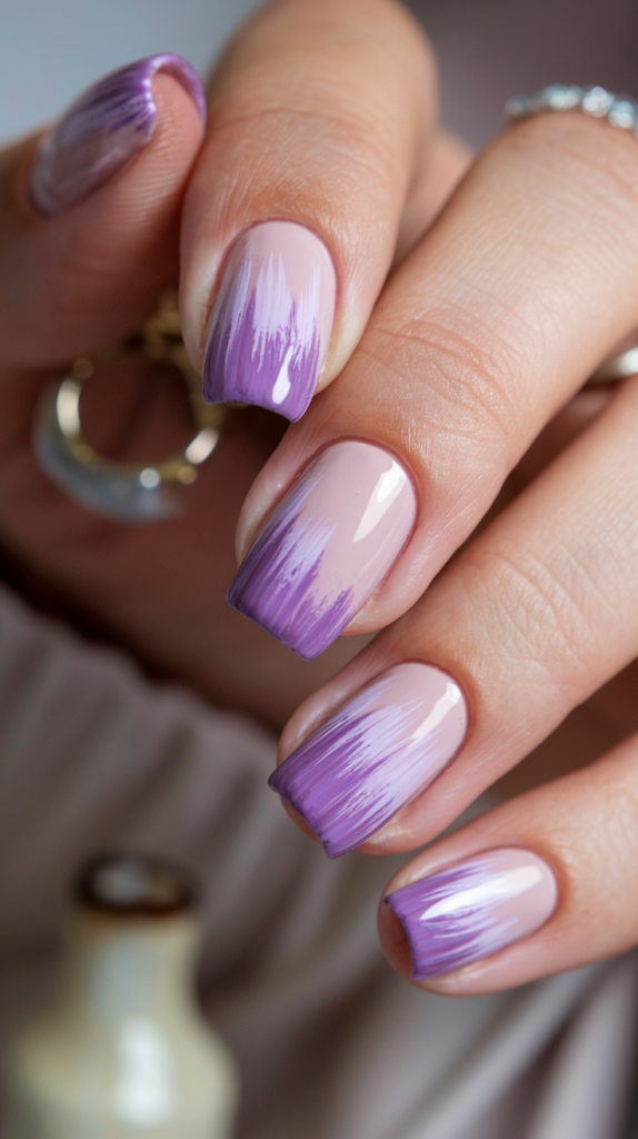 Nude nails featuring abstract, free-form lilac brush strokes for a playful look.
