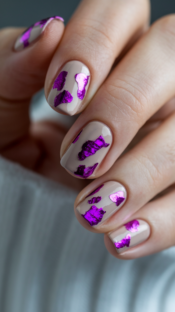 Nude nails with irregular purple metallic foil accents for a modern, abstract look.
