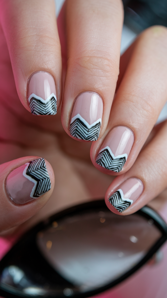 Chic black and white chevron patterns on nails, featuring clean lines and sharp contrasts