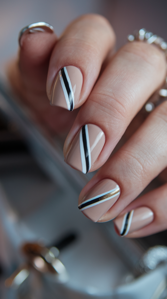 Minimalist nails with small geometric shapes, like triangles and squares, in muted tones