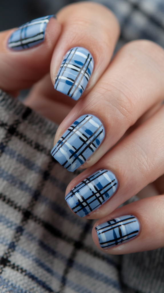 Nails with a blue plaid pattern featuring navy and lighter blue lines, inspired by cozy plaid fabric