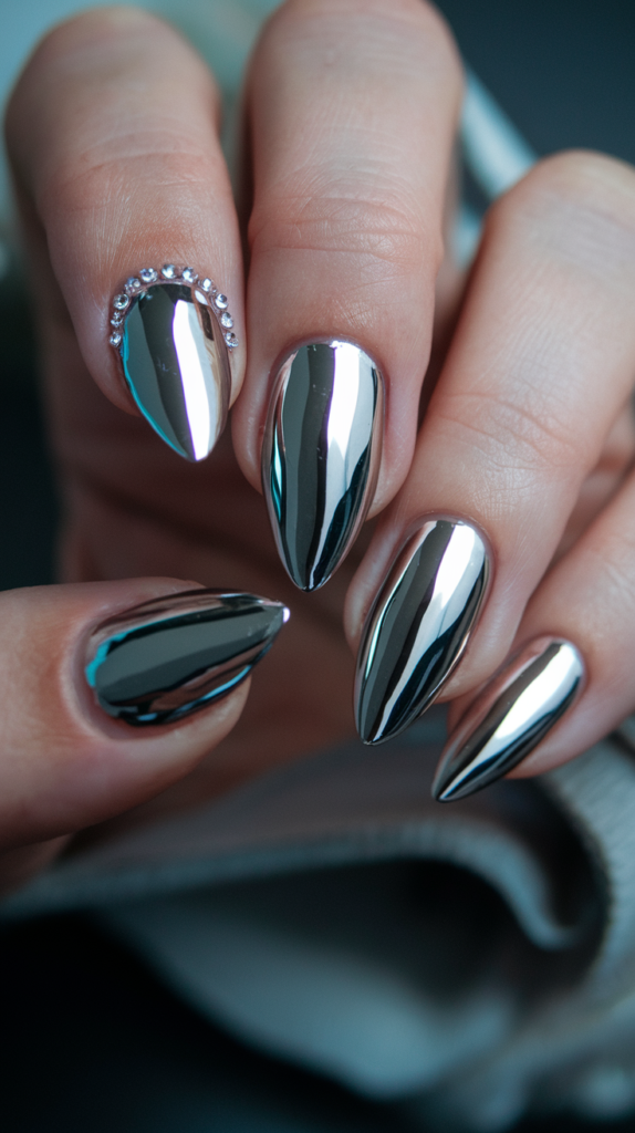 Mirror-effect chrome nails with a sleek, reflective surface, accented with rhinestones along the borders for extra glamour and shine.

