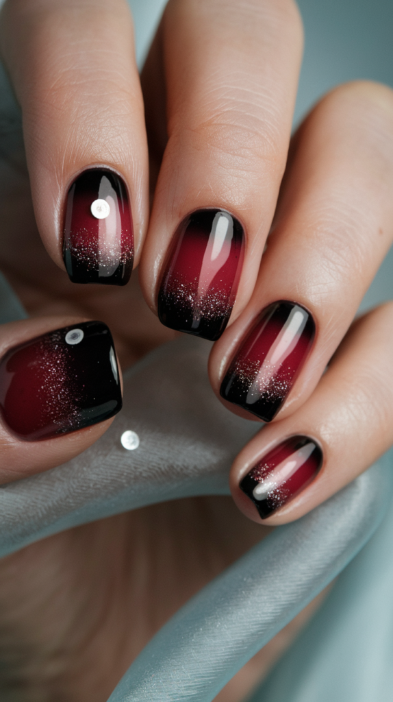 Dramatic ombre effect on nails, blending from deep black to fiery red, perfect for making a bold statement