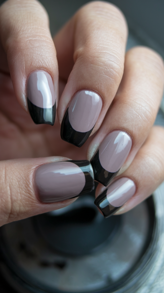 Close-up photo of nails featuring glossy black polish with contrasting matte black tips for a textured look