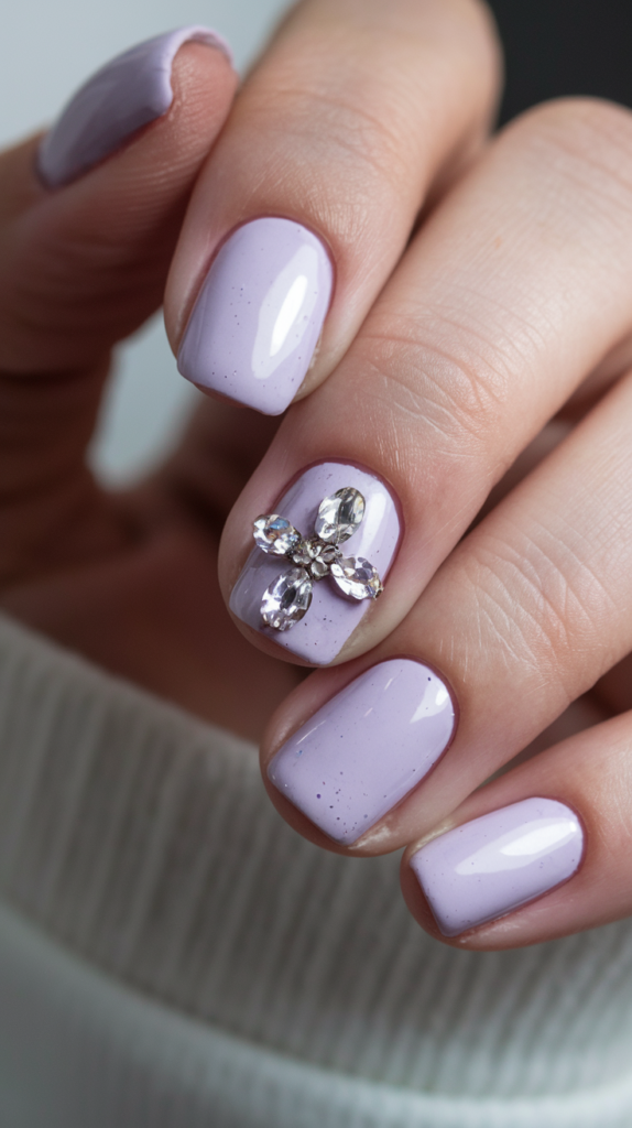 Light purple nails embellished with sparkling rhinestones near the cuticles for added glam.
