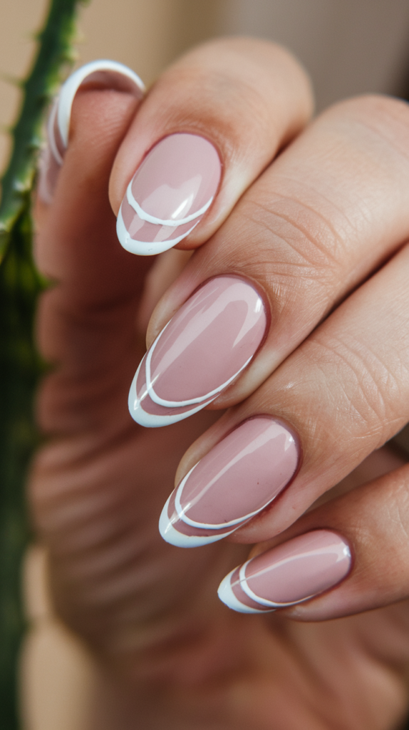 Soft pink nails outlined with thin white lines for a clean, minimalist design