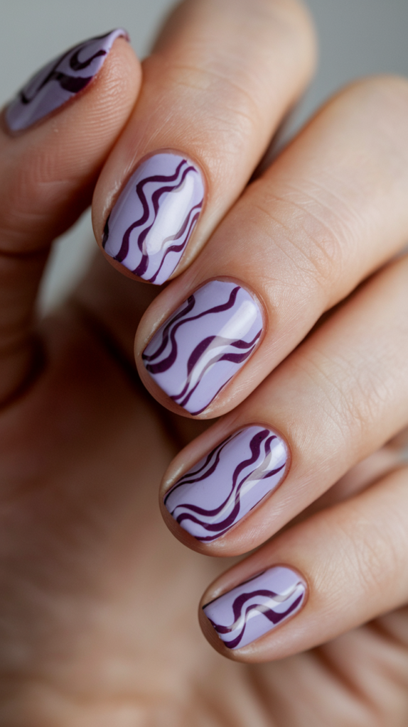 Light purple nails with swirling dark purple designs, creating a dynamic and playful effect