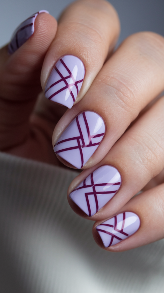 Light purple nails with clean, dark purple geometric stripes for a modern aesthetic.