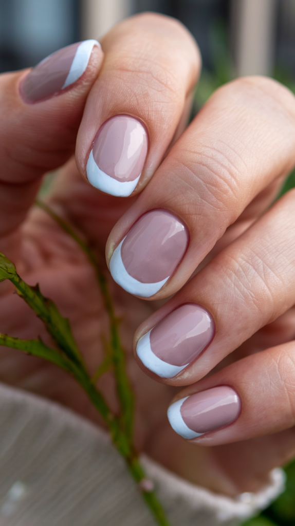 Minimalist nails with small geometric shapes, like triangles and squares, in muted tones