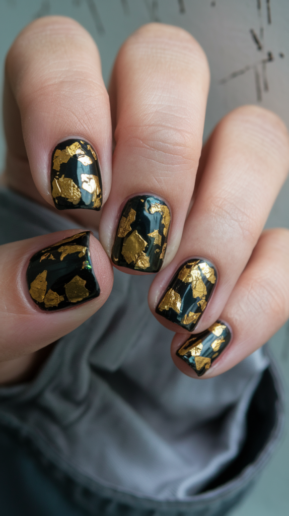 Luxurious black nails embedded with real gold flakes, sparkling subtly for an opulent finish