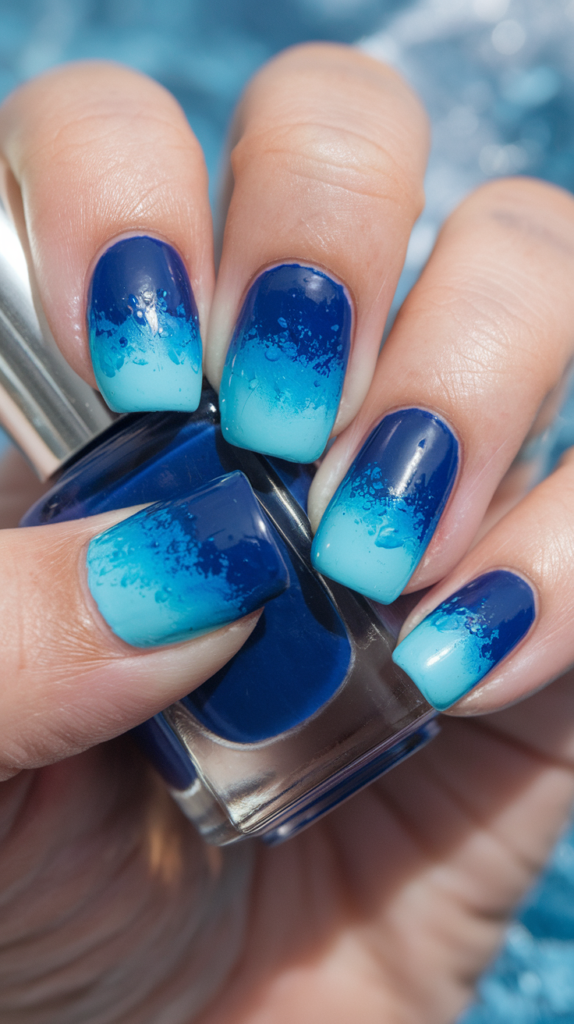 Nails with a smooth gradient of deep navy blending into aqua and pale blue, evoking the colors of ocean waves.