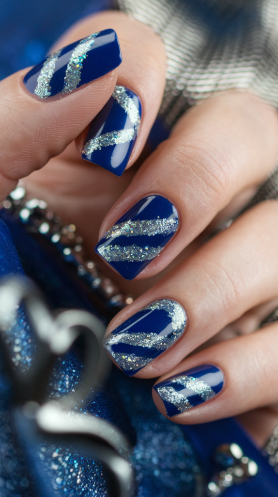 Nails with a royal blue base and silver glitter stripes applied diagonally for a glamorous, modern look