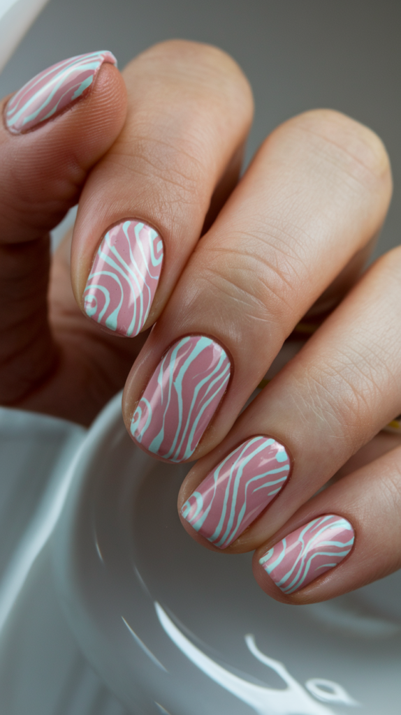 Nails with playful pastel-colored swirls in pink and baby blue, mimicking old telephone cords.

