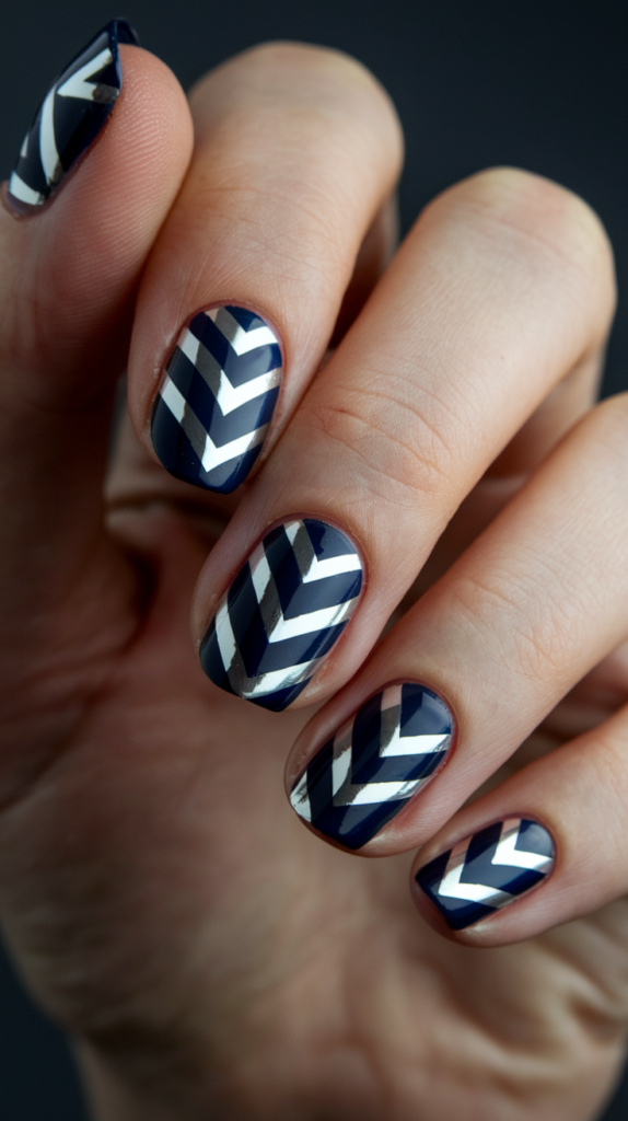 Metallic silver chevron stripes on a deep navy background, showcasing a bold and modern twist on Art Deco nails.
