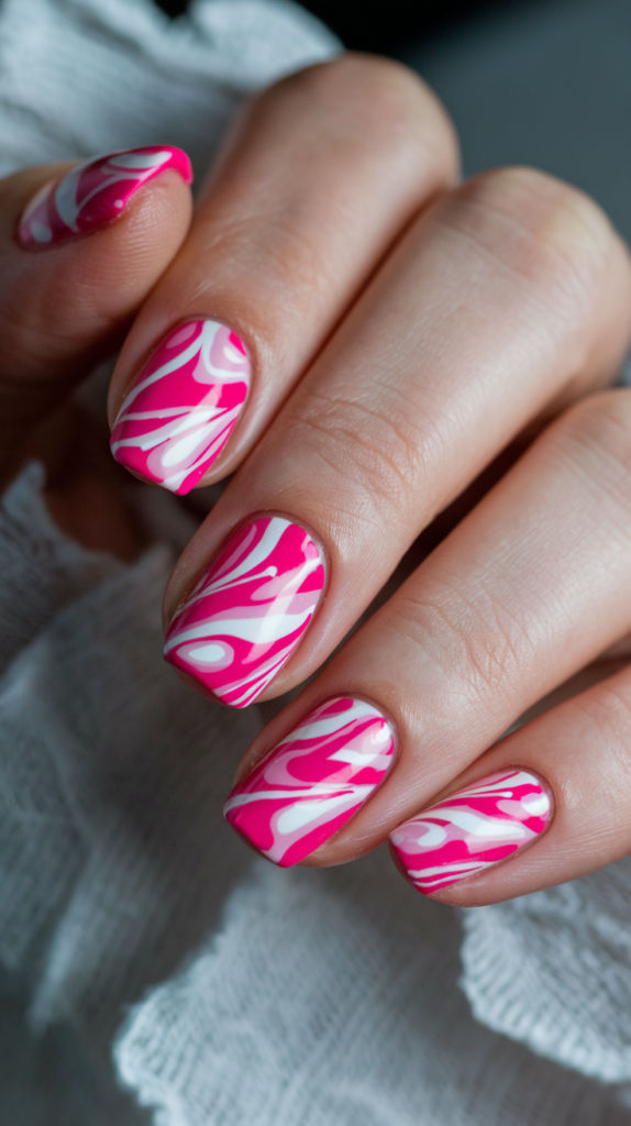 Nails with swirling patterns of various pink shades, mimicking the playful effect of bubblegum.

