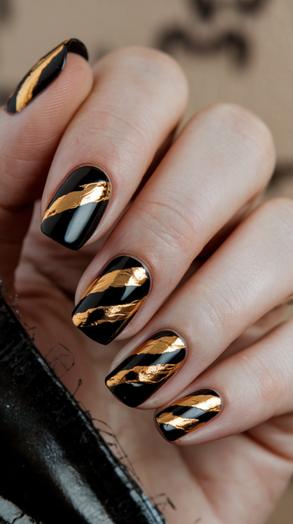 Black nails with bold gold geometric stripes or designs for an elegant, sophisticated look.