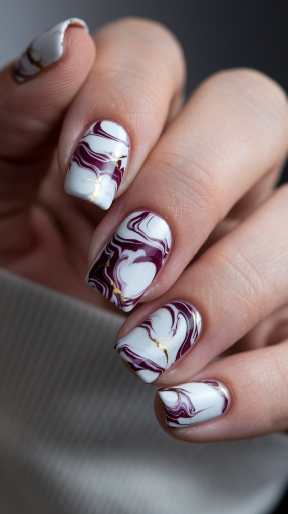 Purple Marble Effect Nails – Nails with white and deep purple swirling marble patterns, featuring fine gold veins for an extra luxurious effect