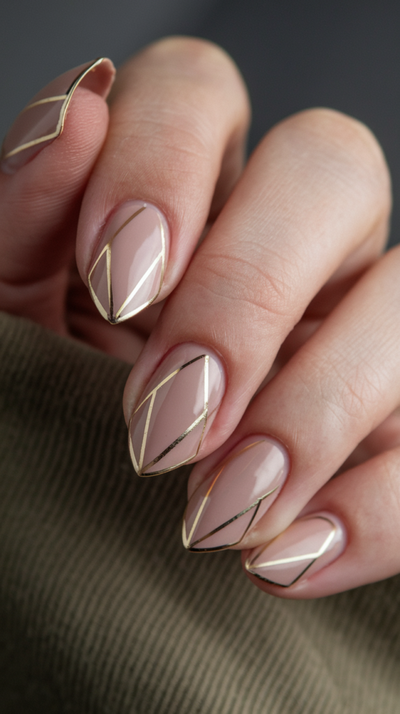 Nude nails with delicate gold triangle tips, providing a minimalist and elegant take on Art Deco nail design.
