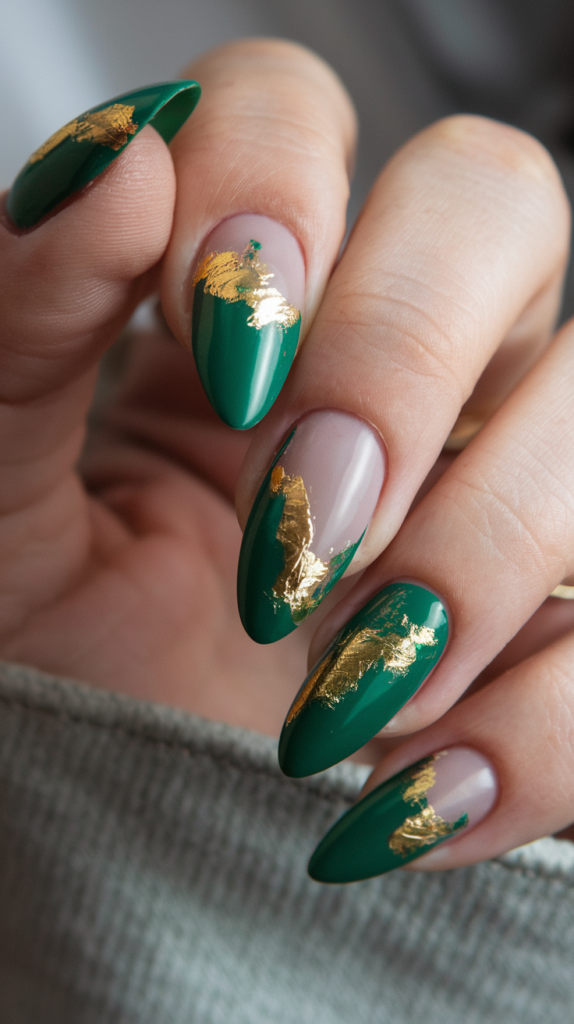 Emerald green nails decorated with shimmering gold foil accents