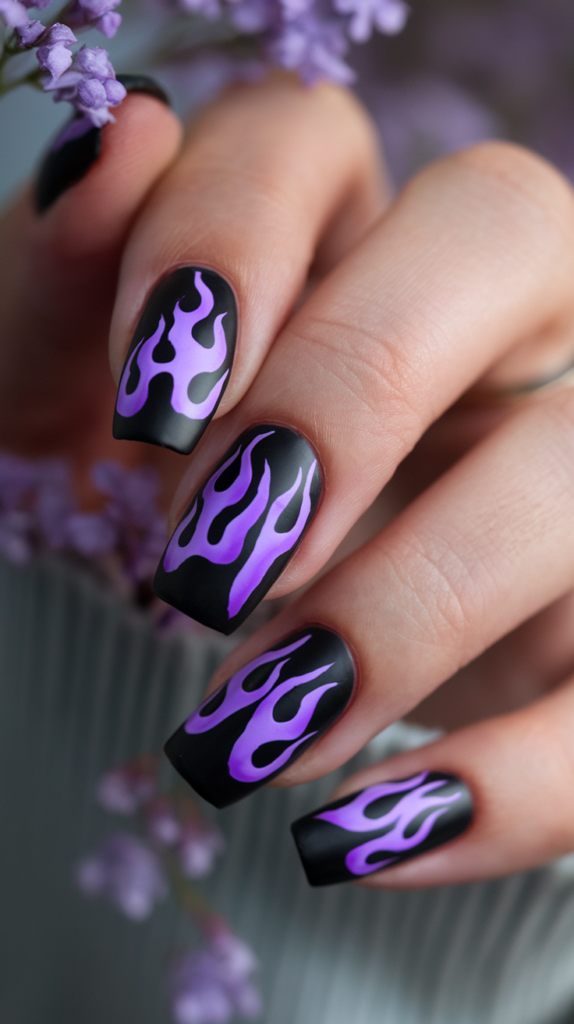 Purple Flame Nails – Black nails with purple flames rising from the tips, transitioning from dark violet to bright lavender for a dynamic look