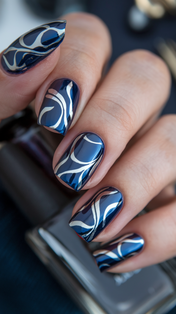 Dark nails with shiny, silver streamers swirling across the surface, giving a high-reflective, party-ready look.
