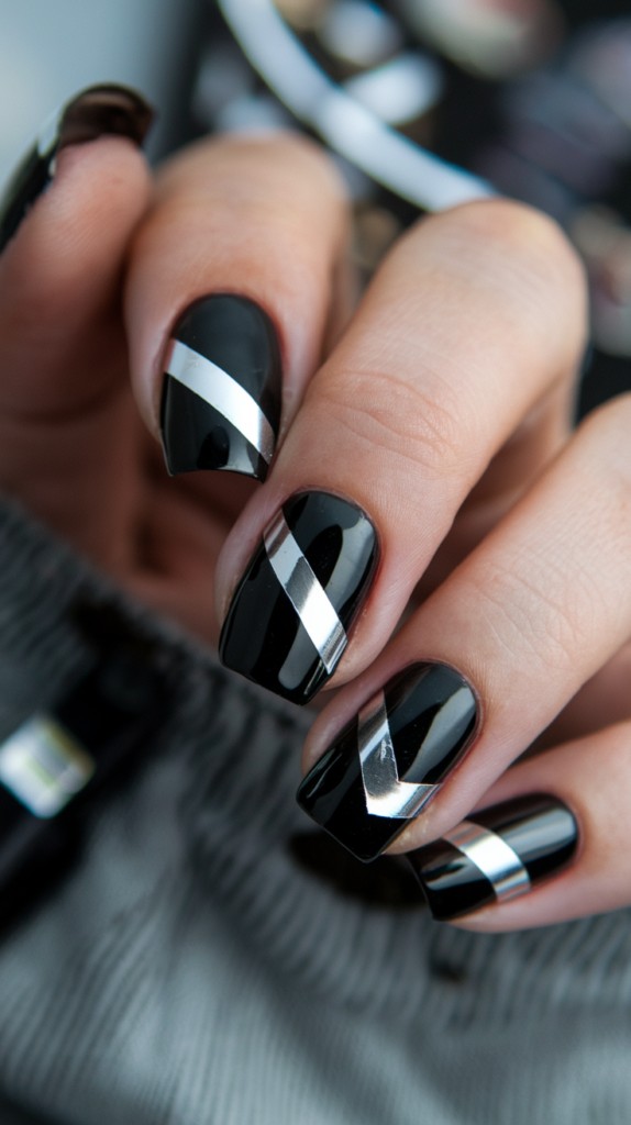 Black nails with thin, metallic reflective strips arranged diagonally across each finger