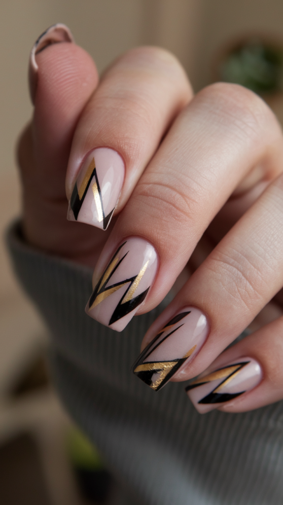 Nude nails with black and gold geometric designs, leaving portions of the nail clear for a modern, negative space Art Deco design.
