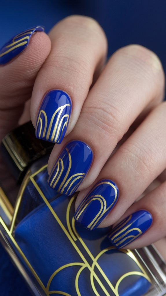 Royal blue nails with gold arches and geometric patterns, creating a bold and elegant Art Deco-inspired look.
