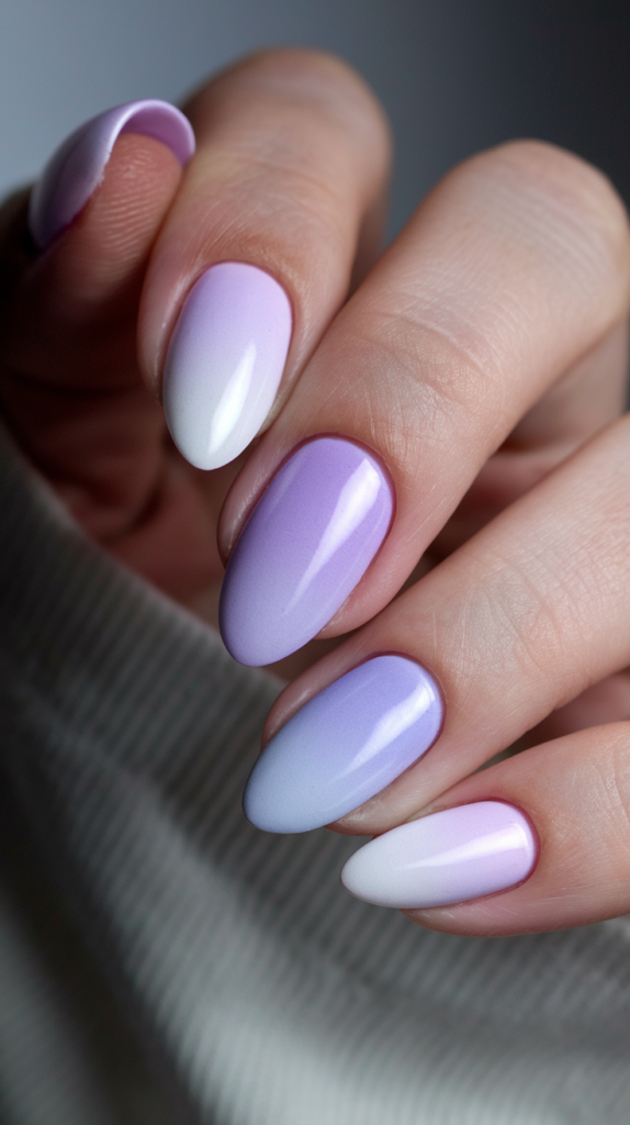 Lilac to Lavender Ombre Nails – Close-up of nails with a soft gradient from pastel lilac at the base to lavender at the tips, with a glossy topcoat