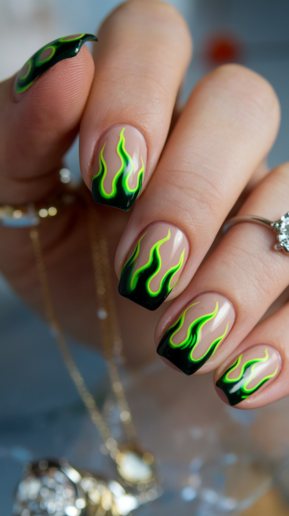 Nails with a nude base featuring vibrant green flames emerging from the tips