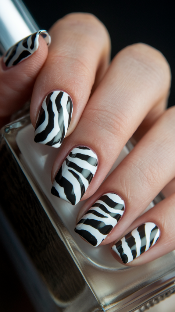 Glossy black and white zebra stripe nail art with uneven, flowing patterns for a timeless look