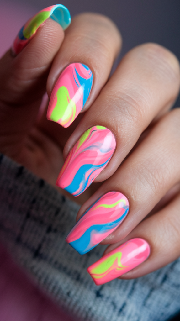 Marble-effect nails with neon pink, blue, and yellow swirls on glossy coffin nails