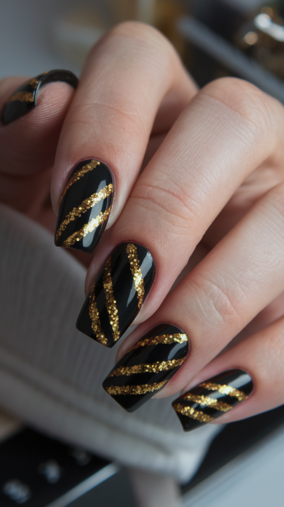 Black nails adorned with bold, glittering gold stripes arranged in a zigzag pattern, offering a glamorous and eye-catching design.
