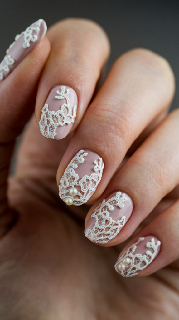 Nails with intricate white lace patterns over a soft pale pink background.

