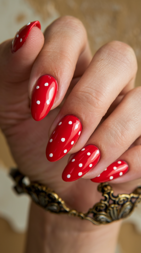 Glossy red nails with an almond shape, reflecting light in a pin-up style.

