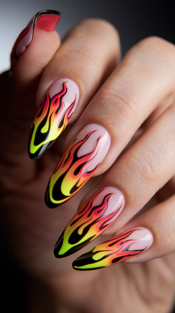 Neon flame nail design with orange and yellow glowing flames on black stiletto nails