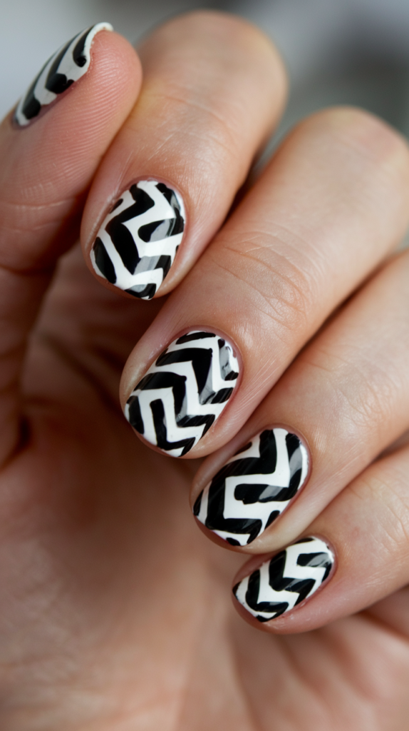 Black-and-white zigzag patterns across nails, with a minimalist touch for a chic vibe