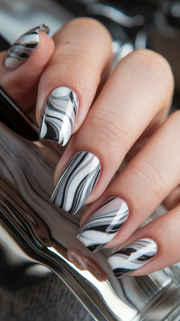 Chic marble-patterned nails with chrome accents integrated into the design for a trendy look