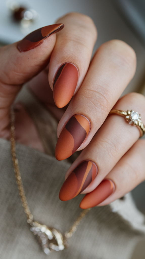 Chic and understated burnt orange nails with a velvety matte finish.
