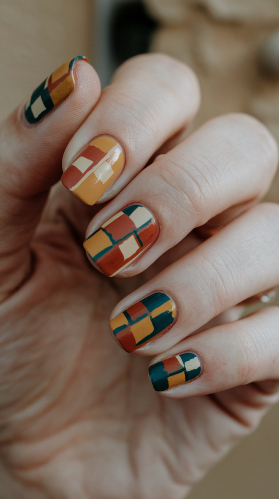 Retro square patterns in bold mustard yellow, teal, and orange, arranged asymmetrically on nails.